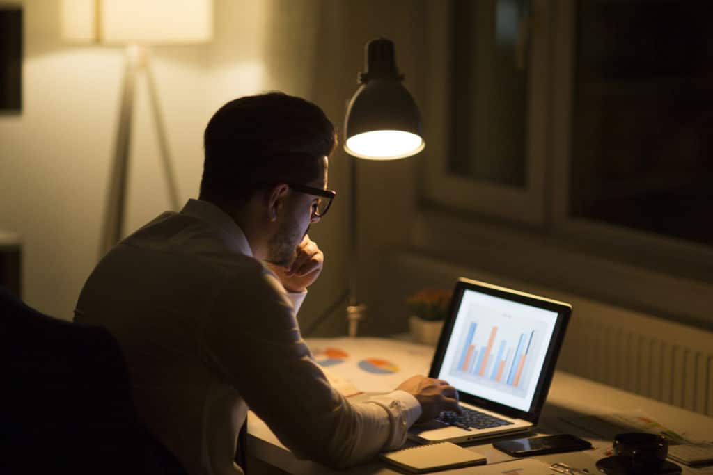 man checking work data at night | employee retention